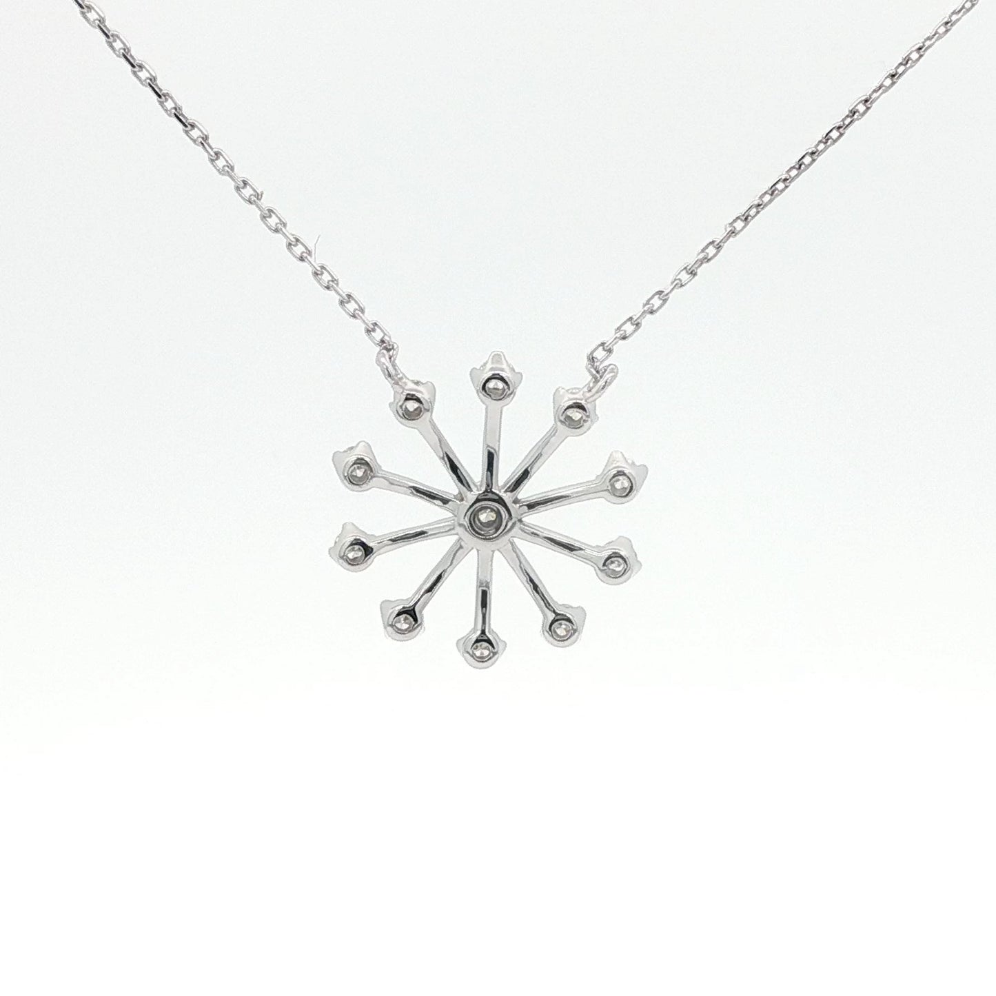 Silver snowflake pendant necklace on a white background