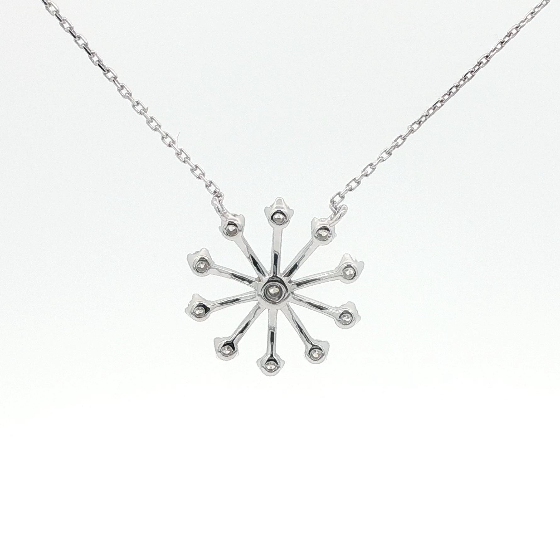 Silver snowflake pendant necklace on a white background